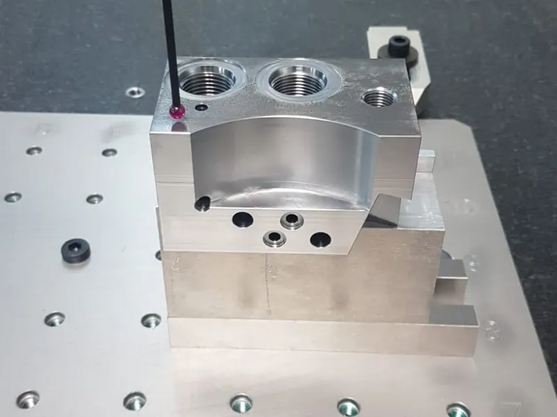 Ventilblock aus S355 mit Gewindeanschlüssen und Bohrbild auf der Koordinatenmessmaschine, Taststift im Einsatz
